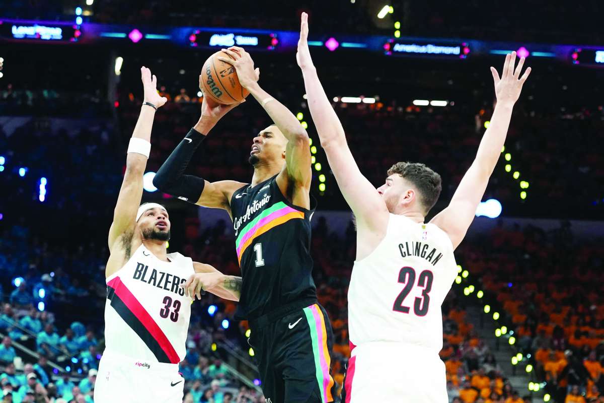 San Antonio Spurs forward Victor Wembanyama (center) drives to the basket between Portland Trail Blazers forward Toumani Camara (left) and center Donovan Clingan during the first half of Game 1 of the 2026 NBA Playoffs. (Scott Wachter / Imagn Images / Reuters)