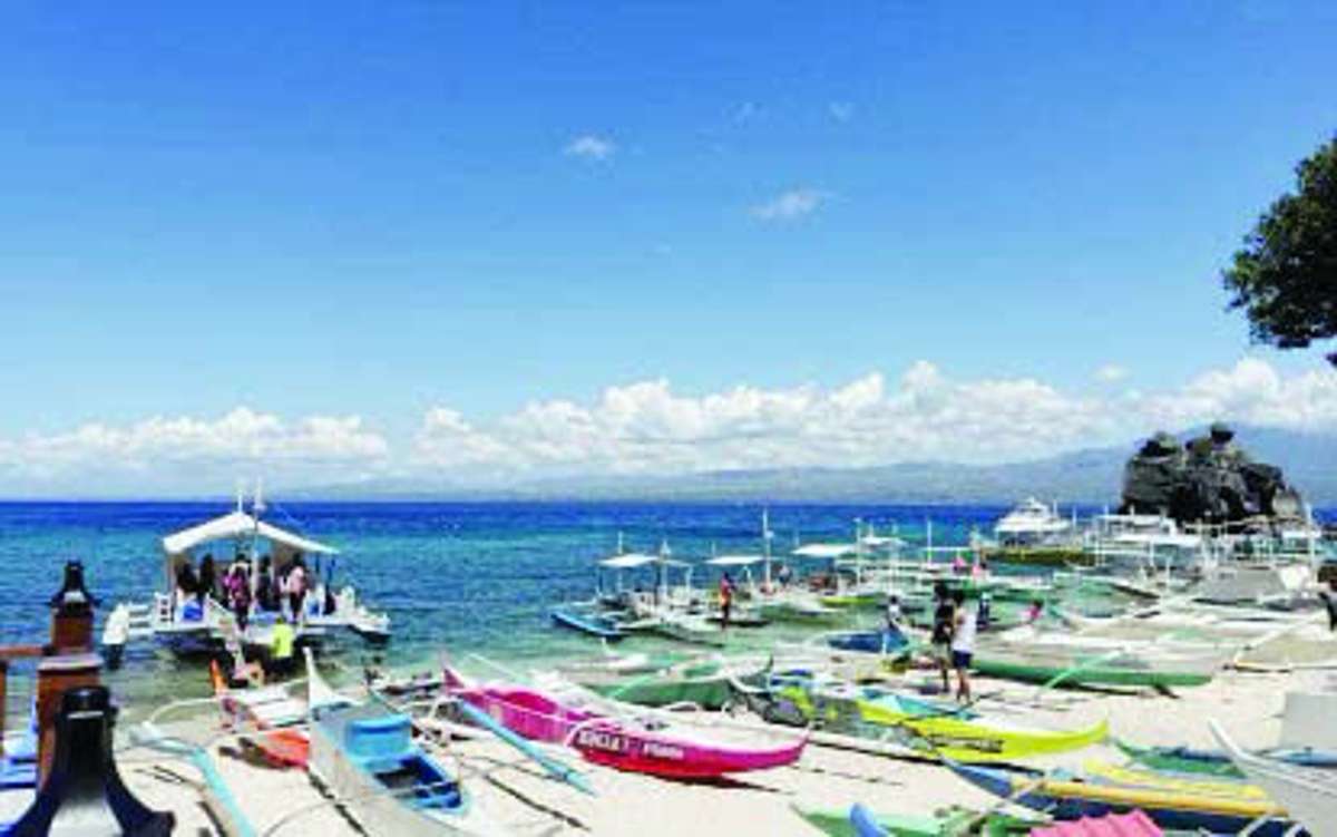 Several motorboats flock to Apo Island in Dauin, Negros Oriental for its annual fiesta celebration on April 5, 2026. The Negros Oriental Chamber of Commerce and Industry is lobbying for reducing the prescribed fees for scuba divers, as the higher rates affect the province’s tourism industry. (Danny Ocampo / Facebook photo)