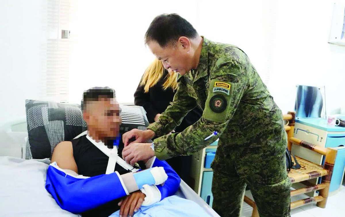 Philippine Army chief Lt. General Antonio Nafarrete pins the Military Merit Medal on the soldier who was wounded in a recent encounter at Barangay Salamanca in Negros Occidental’s Toboso town that left 19 suspected members of the New People’s Army dead. (3ID photo) 