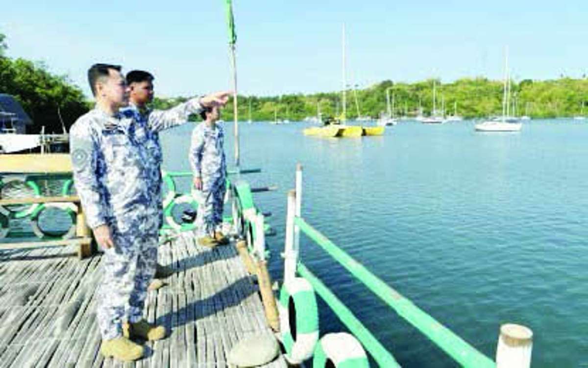 Commodore Christopher Auro (left), commander of the Coast Guard District Southern Visayas, checks on yachts anchored in Tambobo Bay, Siaton, Negros Oriental, on Tuesday afternoon, May 12, 2026. Of the 60 yachts inventoried, 25 are undocumented, unregistered and have no known owners, Auro says. (PNA photo)