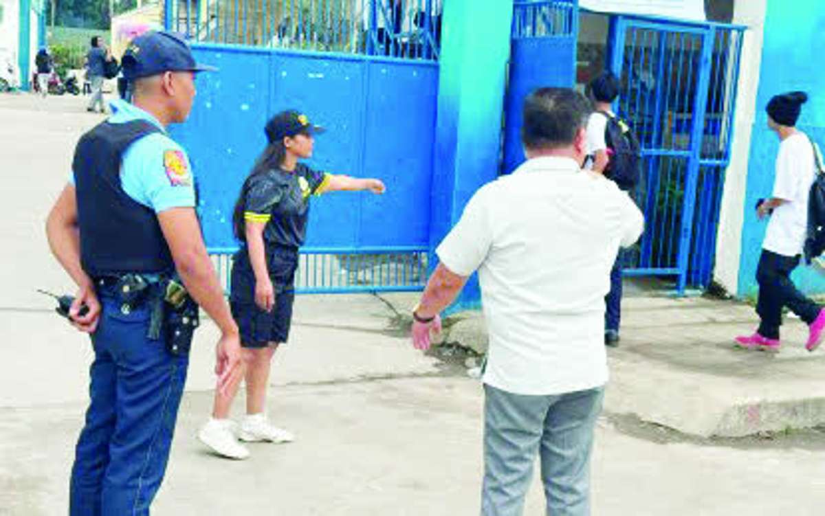 Police and school officials stand guard at the entrance of the Junob National High School in Dumaguete City, Negros Oriental yesterday, June 23, 2026. The Department of Education in the capital has intensified security measures at schools following the deadly shooting in Tacloban City, where two students allegedly shot dead three people and injured learners on campus. (Luisito Mapue Facebook photo)