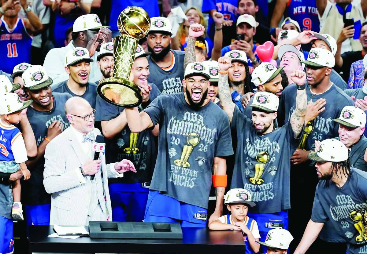 New York Knicks center Karl-Anthony Towns (center) hoists the trophy after defeating the San Antonio Spurs in Game 5 of the 2026 NBA finals. (Dustin Safranek / Imagn Images / Reuters)