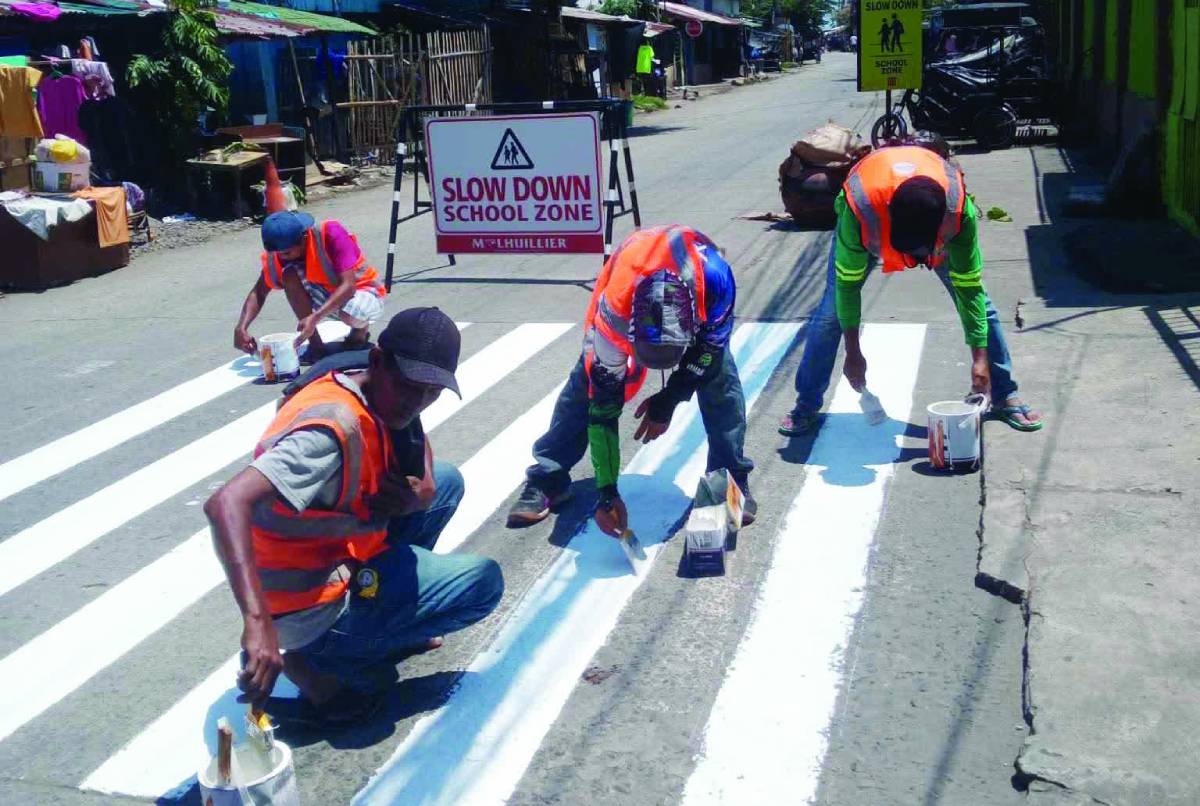 Personnel from the Bacolod City Engineer's Office repainted the pedestrian lanes near public elementary schools, which will enhance students' safety while crossing the road ahead of the opening of classes today, June 8, 2026. (Bacolod City Engineer's Office photo)